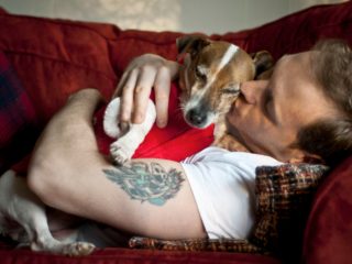 Man holding and cuddling dog